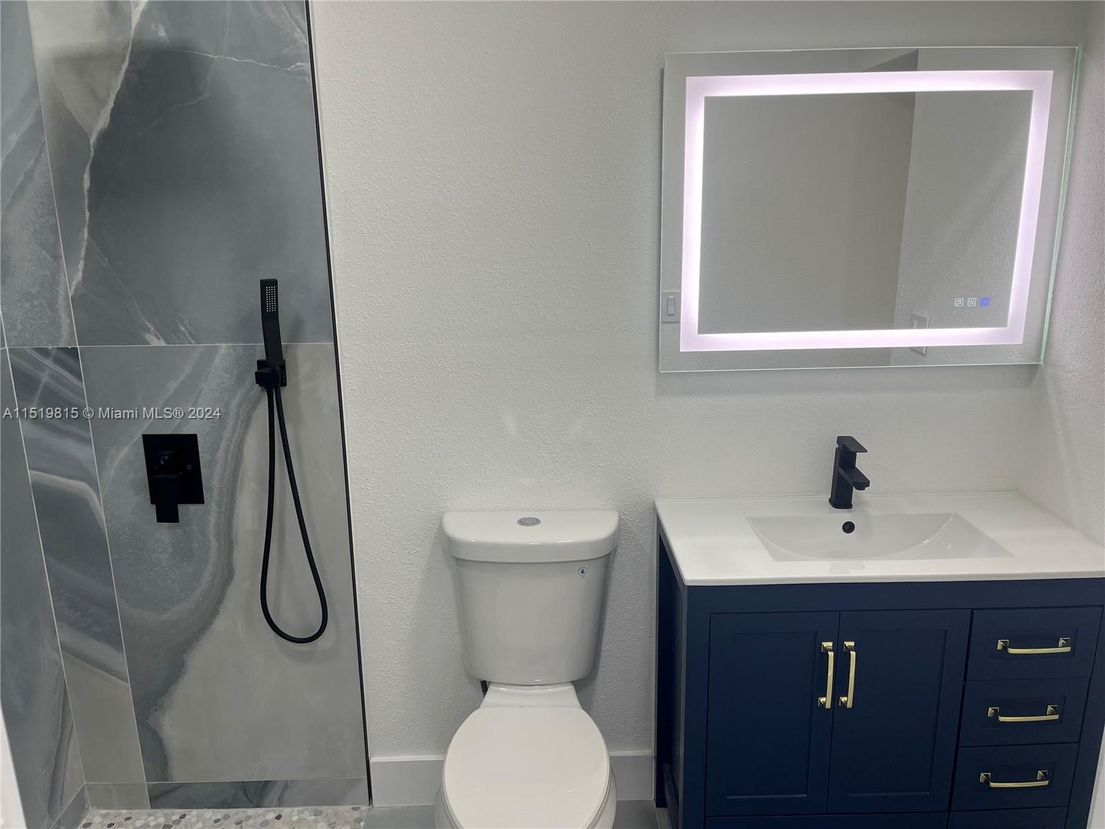 10420 Southwest 42nd Street Miami, FL 33165 - Photo 9 of 17 a bathroom with a toilet sink vanity and mirror