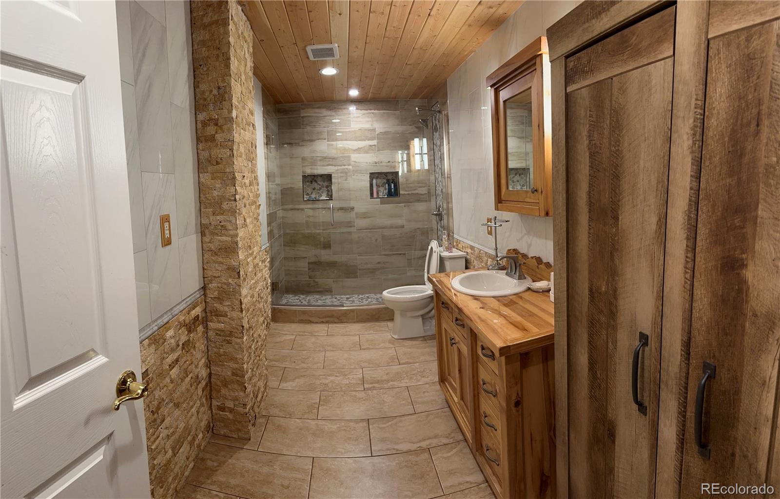 1080 South Dutch Valley Road Bennett, CO 80102 - Photo 12 of 18 a bathroom with a sink a toilet and shower
