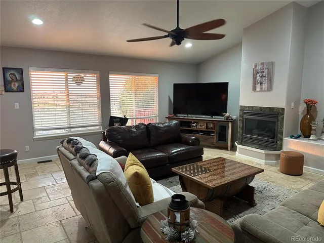 a living room with furniture a flat screen tv and a window