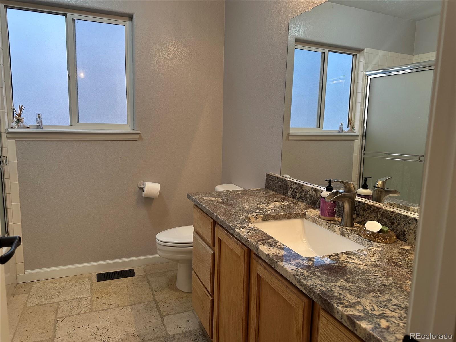 1080 South Dutch Valley Road Bennett, CO 80102 - Photo 9 of 18 a bathroom with a granite countertop sink and a toilet