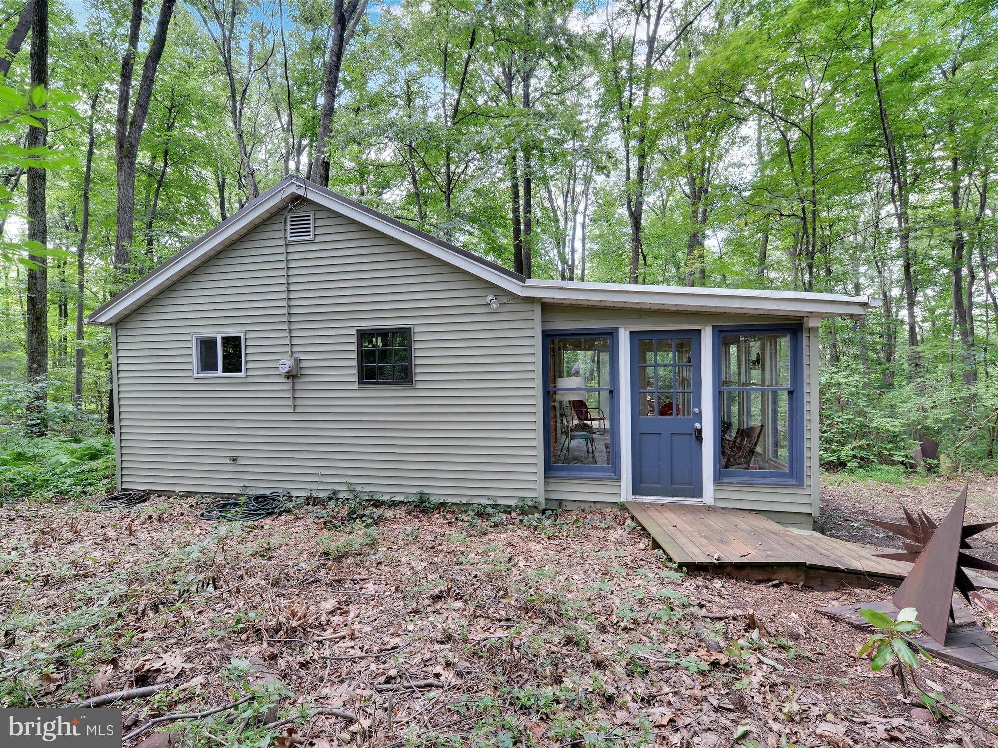 540 Hill Road Denver, PA 17517 - Photo 3 of 25 a view of a house with a small yard plants and large trees