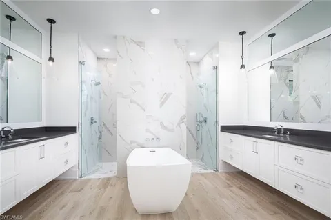 a bathroom with a granite countertop sink a toilet a mirror and shower