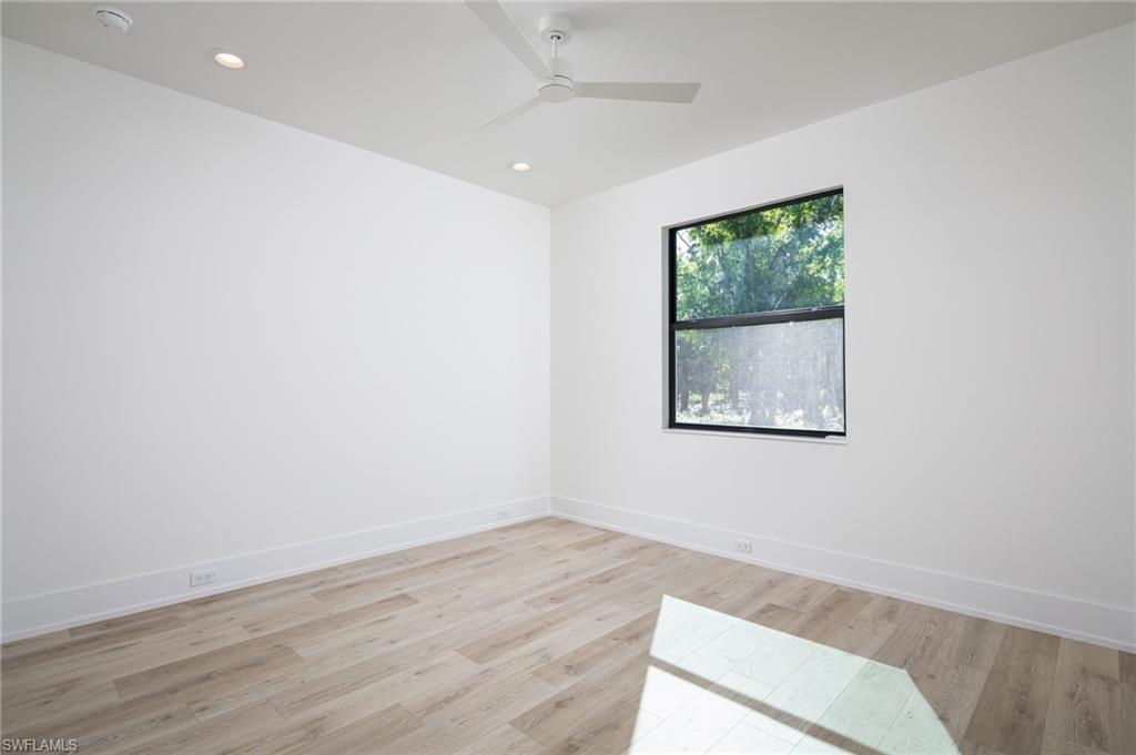 5772 Green Boulevard Naples, FL 34116 - Photo 14 of 24 an empty room with wooden floor and windows