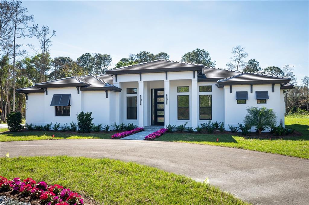 5772 Green Boulevard Naples, FL 34116 - Photo 2 of 24 a front view of a house with a yard