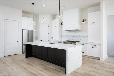 a kitchen with stainless steel appliances granite countertop a sink a stove and a refrigerator