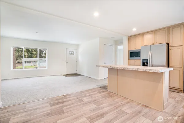 a view of kitchen with wooden floor and electronic appliances