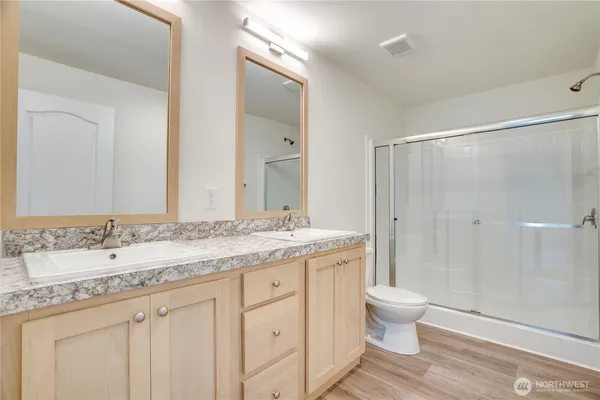 a bathroom with a granite countertop sink toilet and shower