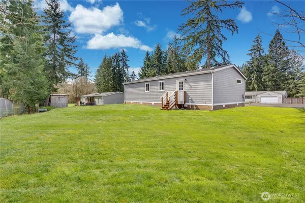 a view of a house with a big yard and large trees