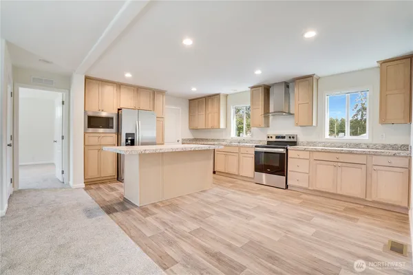 a kitchen with a refrigerator and a stove top oven