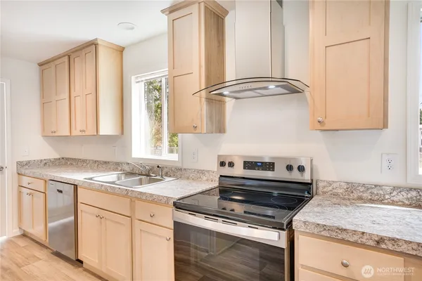 a kitchen with stainless steel appliances granite countertop a sink stove and cabinets