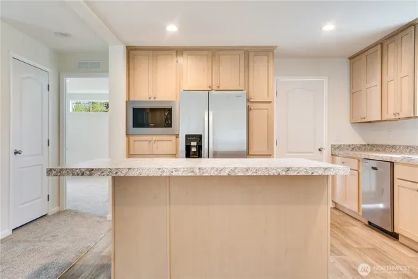 a kitchen with stainless steel appliances granite countertop a stove a sink and a refrigerator