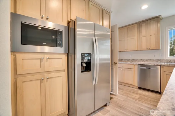a kitchen with stainless steel appliances granite countertop a refrigerator and a stove top oven