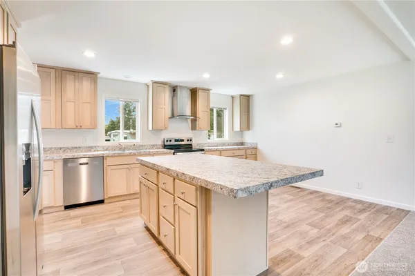 a kitchen with stainless steel appliances granite countertop a sink stove and refrigerator