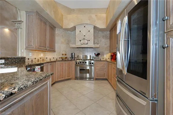 a kitchen with stainless steel appliances granite countertop a refrigerator and a stove