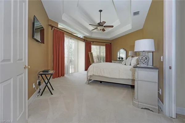 a bedroom with a bed chandelier and a window