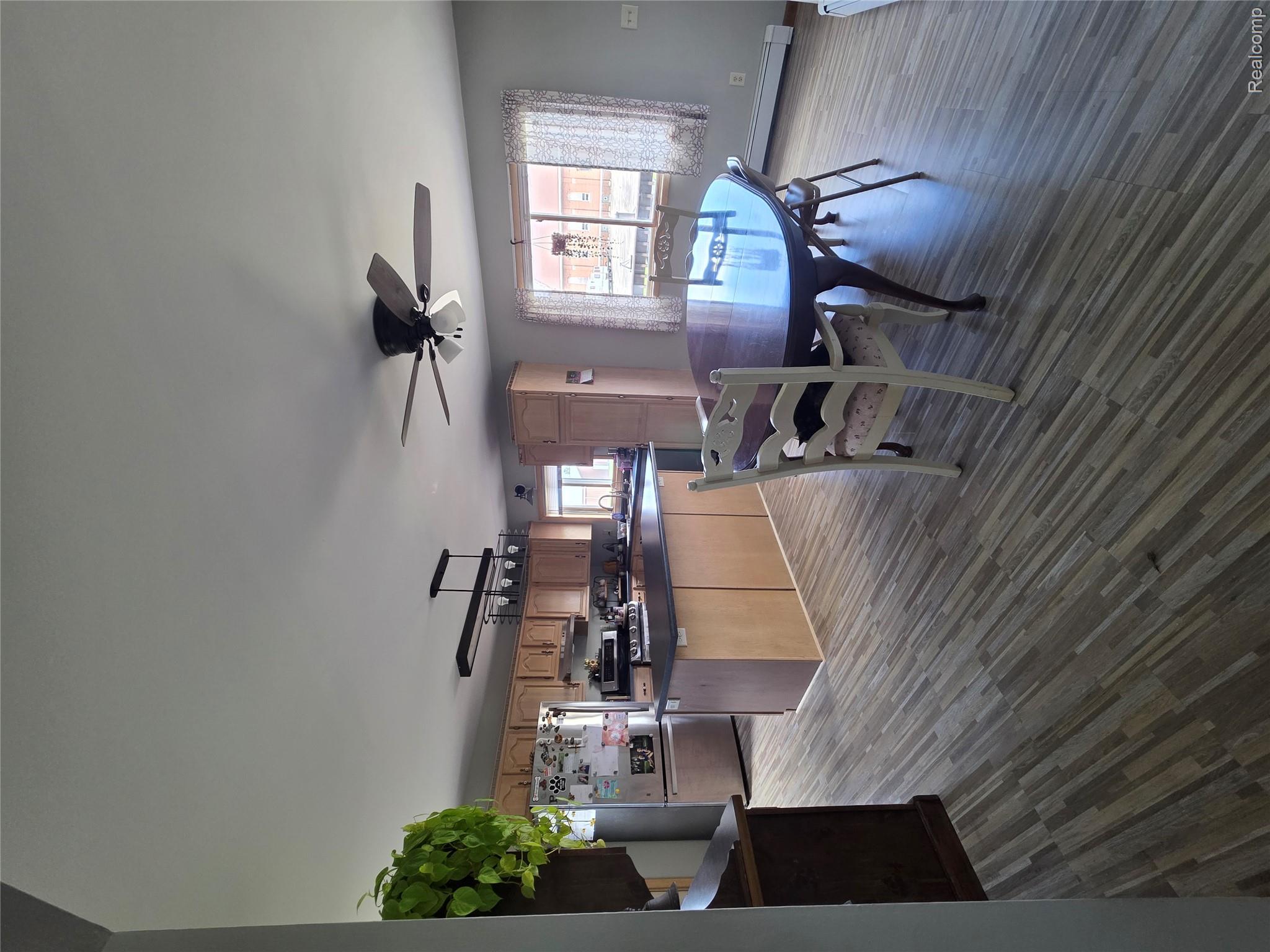 5847 F Road Bark River, MI 49807 - Photo 14 of 25 Dining area featuring a ceiling fan, baseboard heating, and dark wood-style flooring