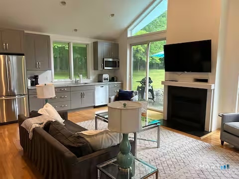 9 Fall Ridge Road Weston, CT 06883 - Photo 29 of 39 Living room with gas fireplace and view to kitchenette area (in cottage)