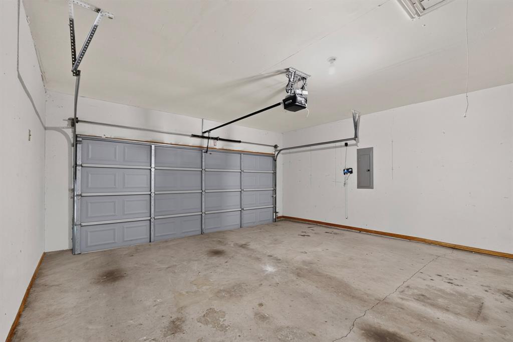 14908 Riverside Drive Little Elm, TX 75068 - Photo 37 of 40 Attached garage with a gray sectional door, concrete flooring, and an overhead door opener