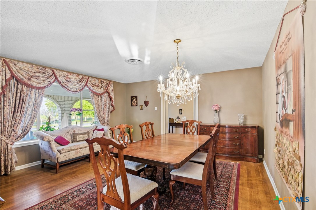 911 West Constitution Street Victoria, TX 77901 - Photo 12 of 42 a view of a dining room with furniture a chandelier and wooden floor