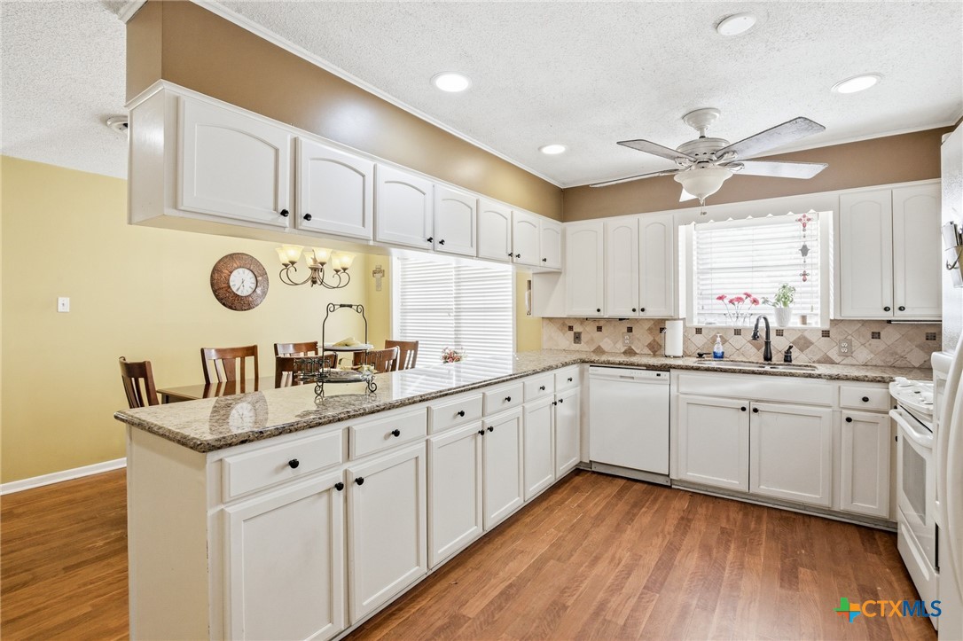 911 West Constitution Street Victoria, TX 77901 - Photo 13 of 42 a kitchen with sink cabinets and wooden floor