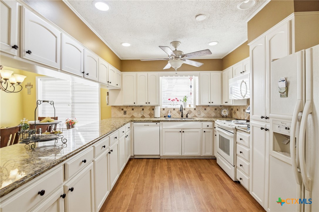 911 West Constitution Street Victoria, TX 77901 - Photo 14 of 42 a large kitchen with stainless steel appliances lots of white cabinets and wooden floors