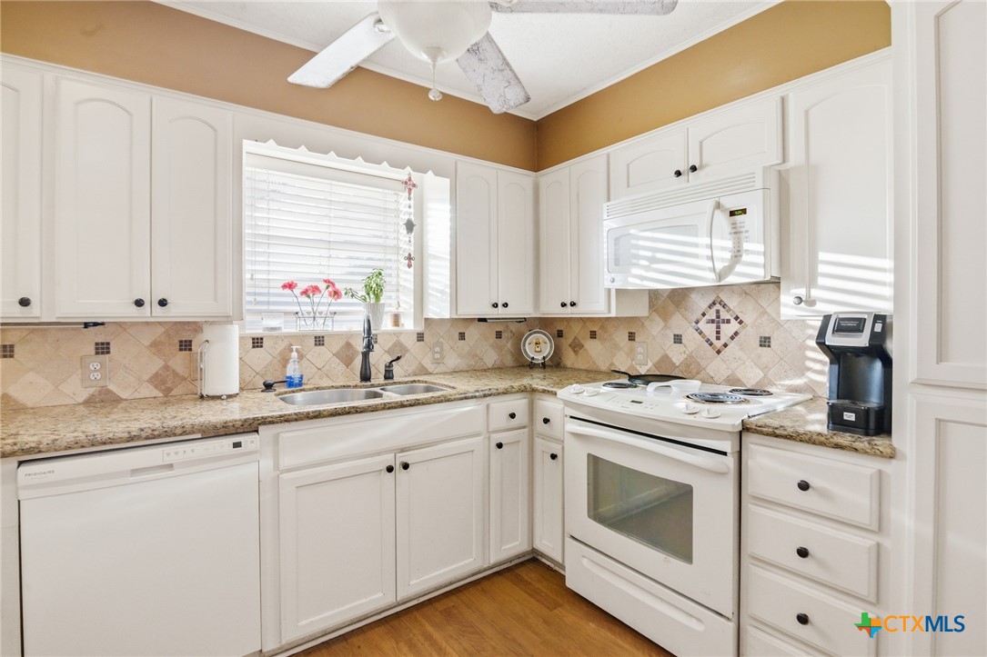 911 West Constitution Street Victoria, TX 77901 - Photo 16 of 42 a kitchen with granite countertop cabinets stainless steel appliances a sink and a window