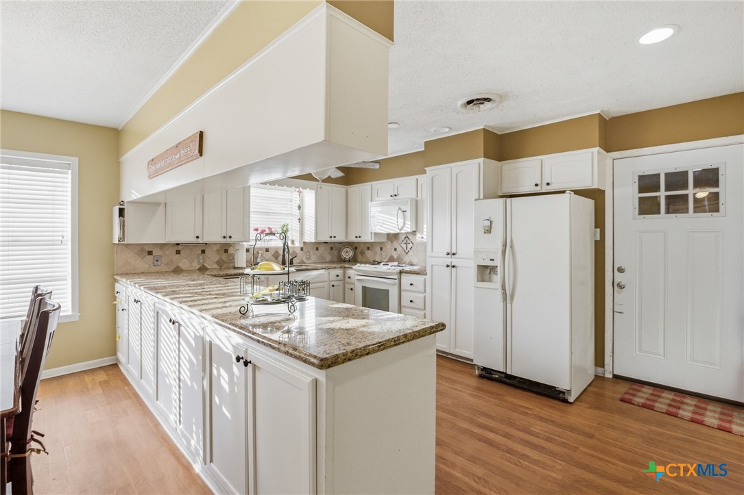 911 West Constitution Street Victoria, TX 77901 - Photo 17 of 42 a kitchen with stainless steel appliances granite countertop a sink and a refrigerator