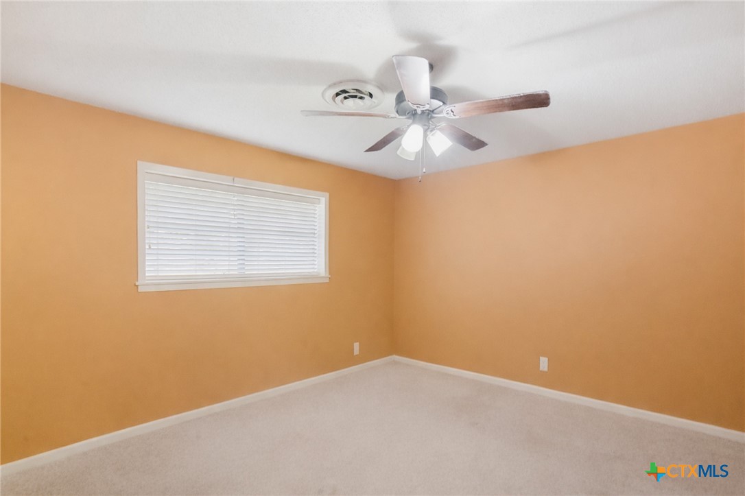 911 West Constitution Street Victoria, TX 77901 - Photo 19 of 42 an empty room with a window and a fan