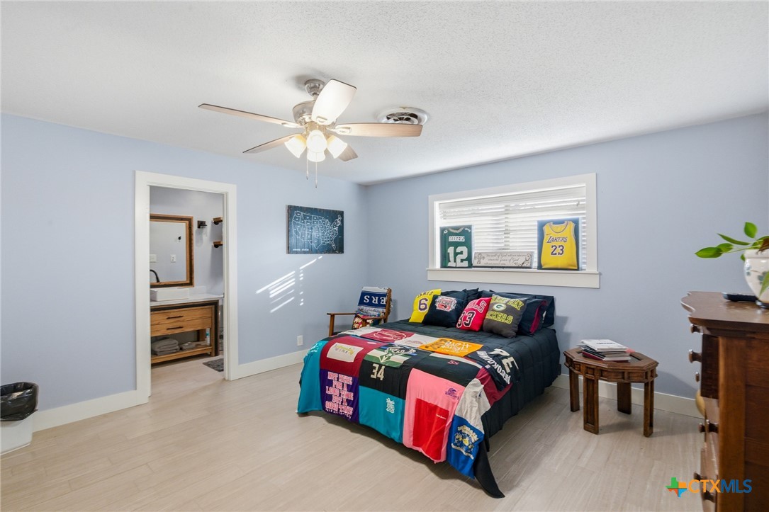 911 West Constitution Street Victoria, TX 77901 - Photo 22 of 42 a bedroom with a bed and a chandelier