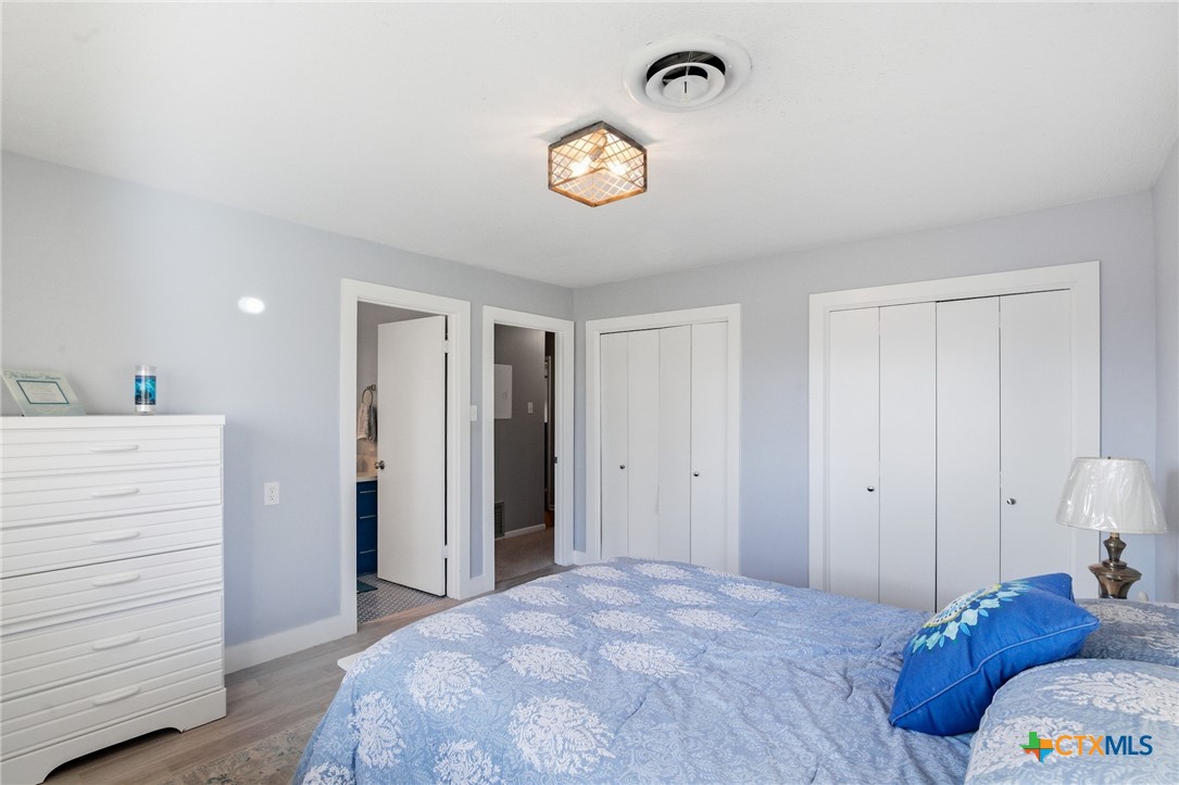 911 West Constitution Street Victoria, TX 77901 - Photo 24 of 42 a bedroom with a bed and a chandelier