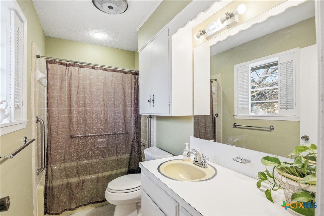 911 West Constitution Street Victoria, TX 77901 - Photo 30 of 42 a bathroom with a granite countertop sink toilet a mirror and shower