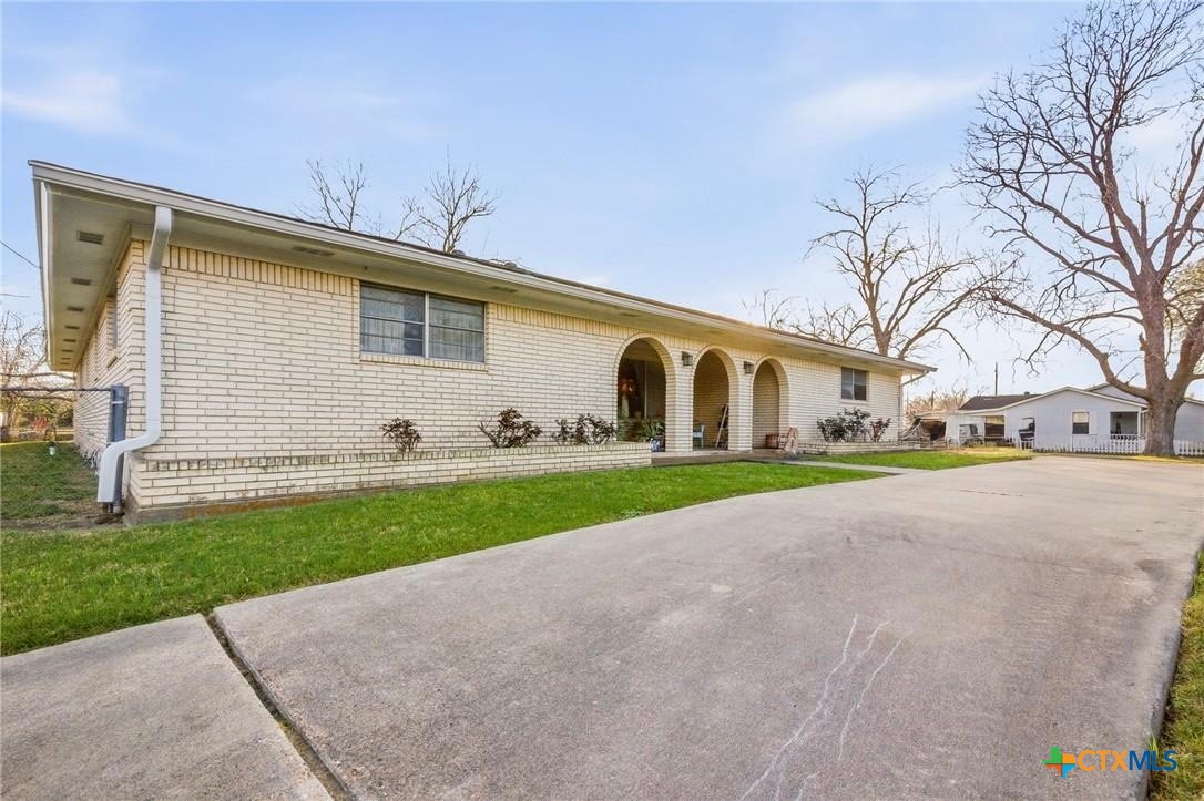 911 West Constitution Street Victoria, TX 77901 - Photo 4 of 42 a view of a white house with a yard and large tree
