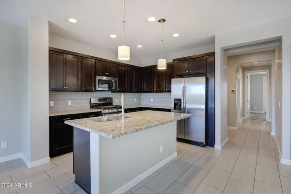 a kitchen with stainless steel appliances granite countertop wooden cabinets a stove top oven a sink and dishwasher