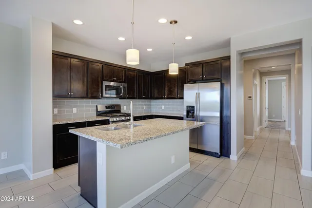 a kitchen with stainless steel appliances granite countertop wooden cabinets a stove top oven a sink and dishwasher