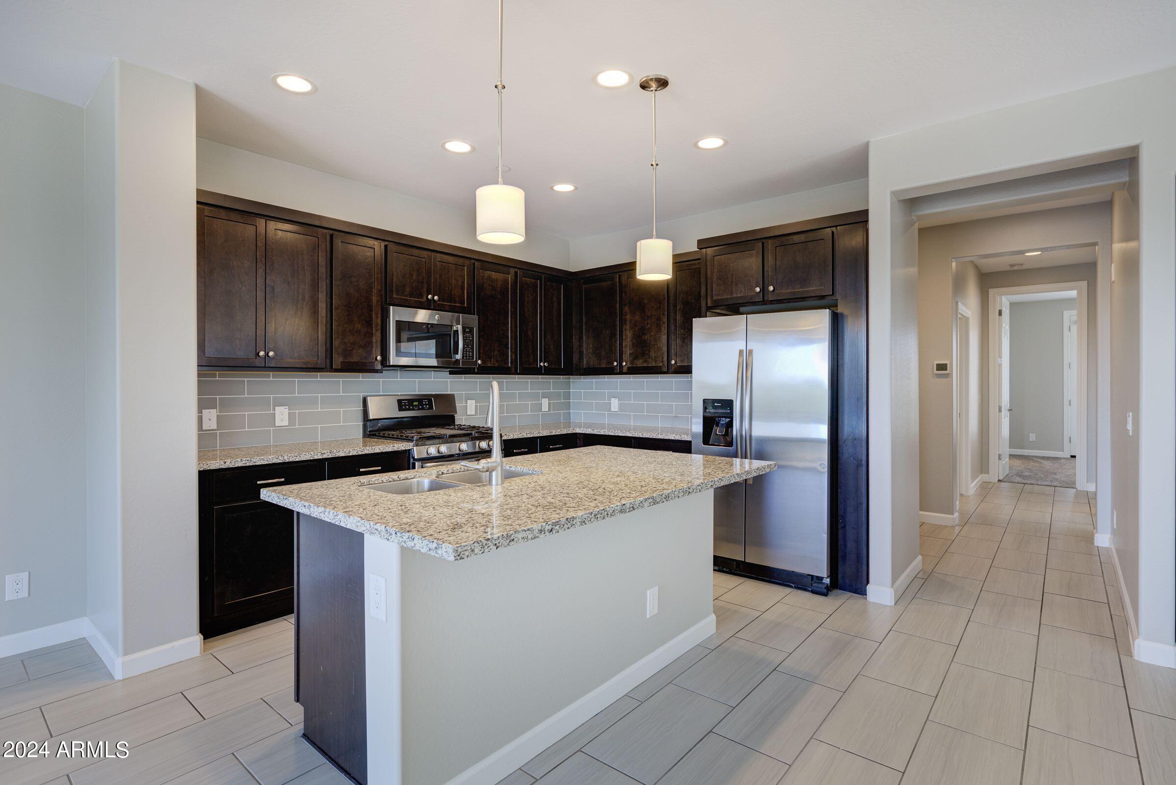 4777 South Fulton Ranch Boulevard, Unit 2066 Chandler, AZ 85248 - Photo 14 of 46 a kitchen with stainless steel appliances granite countertop a sink stove and refrigerator