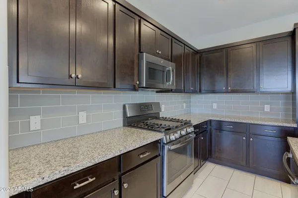 a kitchen with granite countertop a sink stainless steel appliances and cabinets