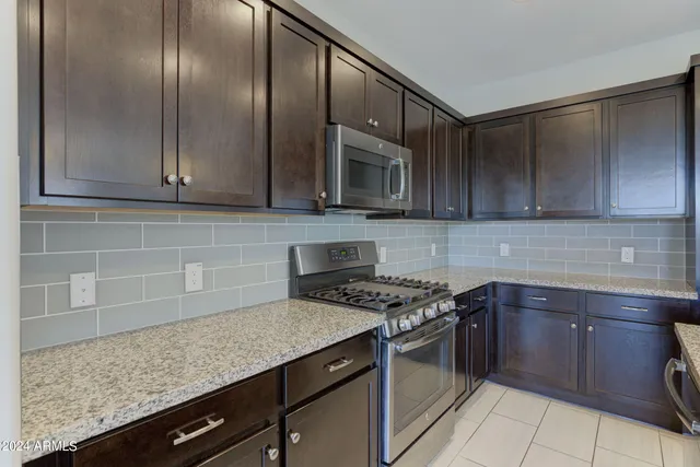 a kitchen with granite countertop a sink stainless steel appliances and cabinets