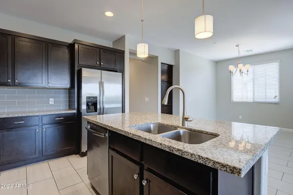 a kitchen with granite countertop a sink a counter top space and living room view