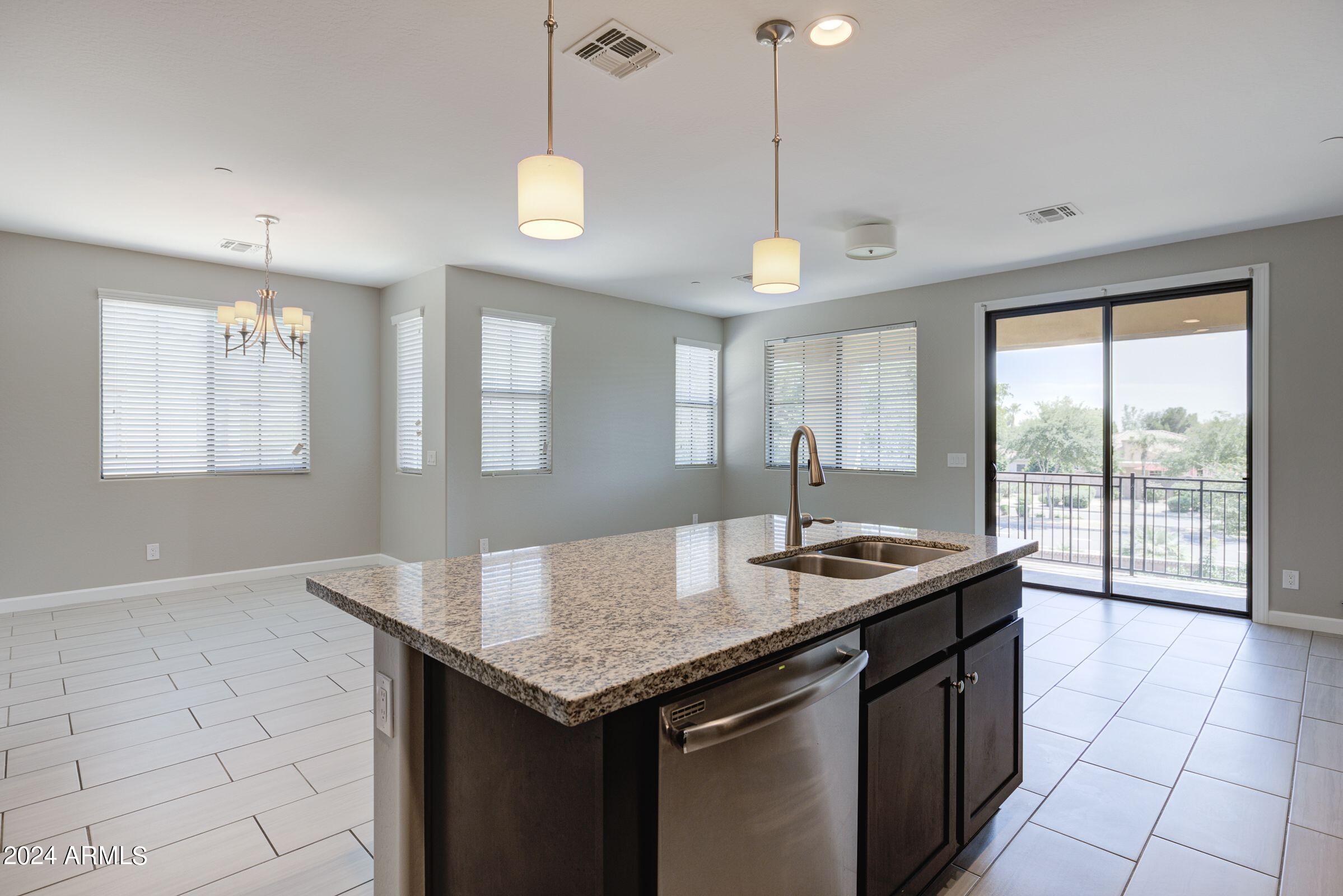 4777 South Fulton Ranch Boulevard, Unit 2066 Chandler, AZ 85248 - Photo 17 of 46 a kitchen with granite countertop a sink a counter top space and living room view
