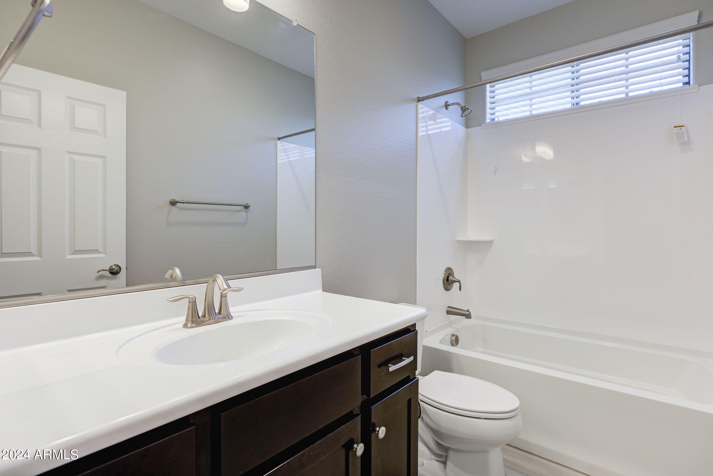 4777 South Fulton Ranch Boulevard, Unit 2066 Chandler, AZ 85248 - Photo 22 of 46 a bathroom with a sink a toilet a mirror and shower