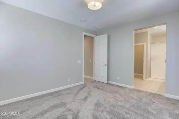 a view of an empty room with closet and a window