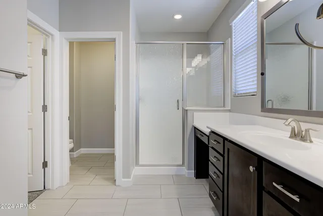 a bathroom with a granite countertop toilet a sink and a mirror