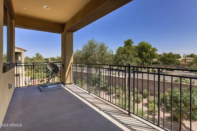 a view of a patio with table and chairs potted plants and floor to ceiling window