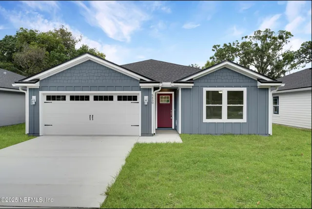 a front view of a house with a garden and yard
