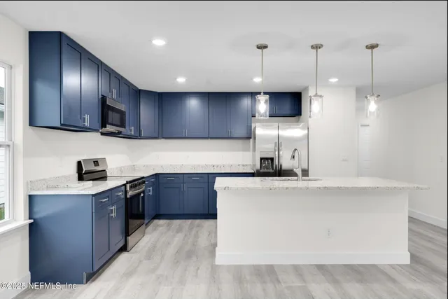 a kitchen with kitchen island granite countertop wooden cabinets and stainless steel appliances