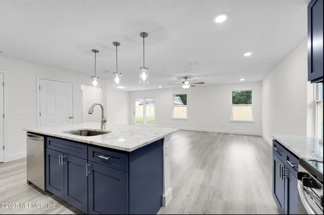 a kitchen with a sink chandelier and wooden floor