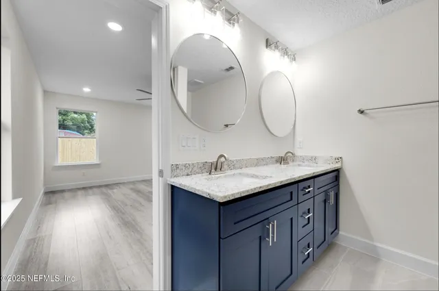 a bathroom with a granite countertop sink a mirror and a vanity