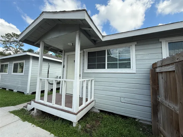 a view of wooden house with a small yard