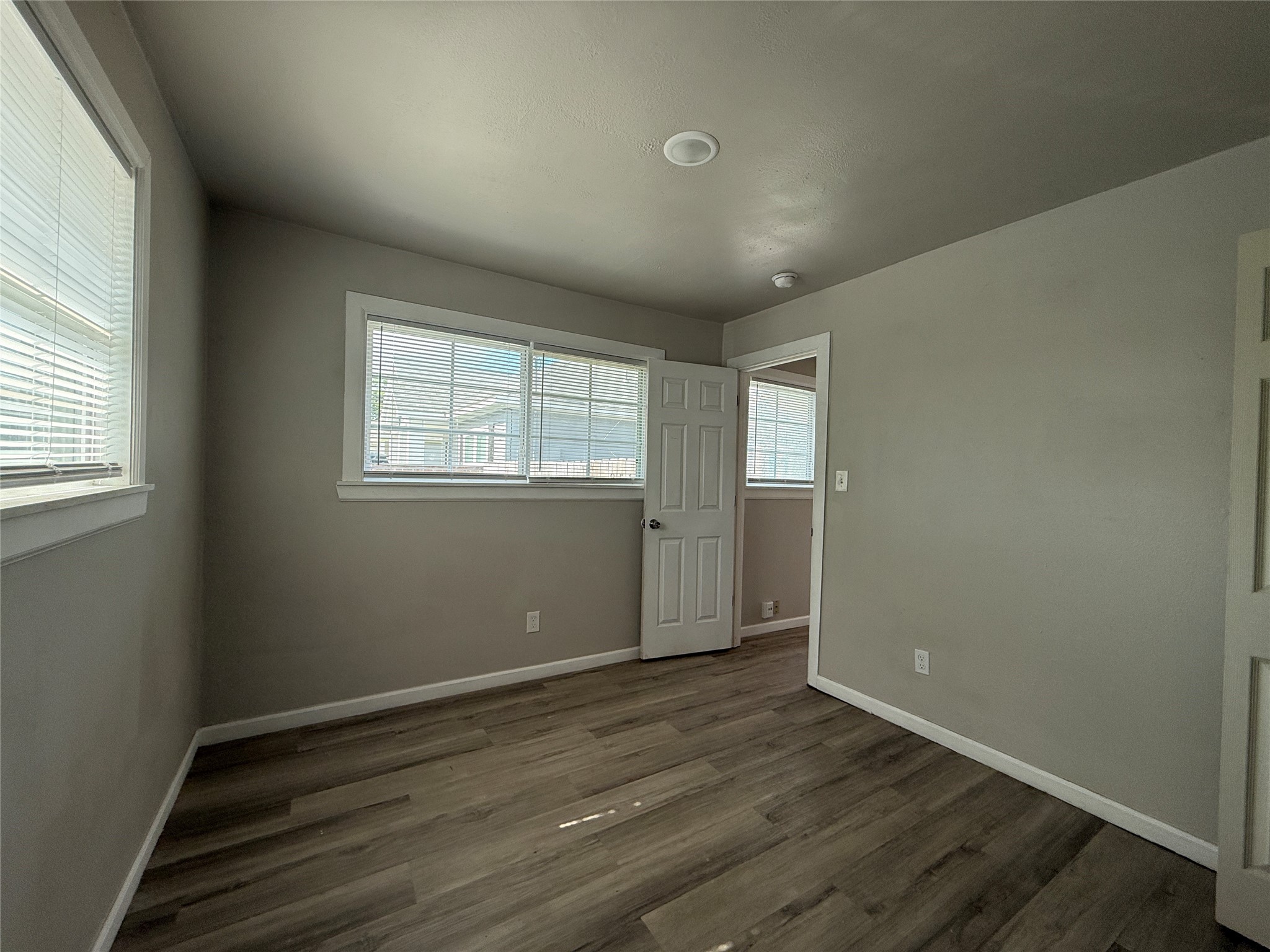 8510 Safeguard Street, Unit 3 Houston, TX 77051 - Photo 7 of 11 an empty room with wooden floor and windows