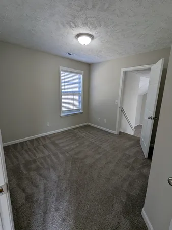 an empty room with a fireplace and windows